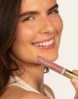 Model wearing Glowify Juicy Plumping Lip Gloss product shade Petal Plump.