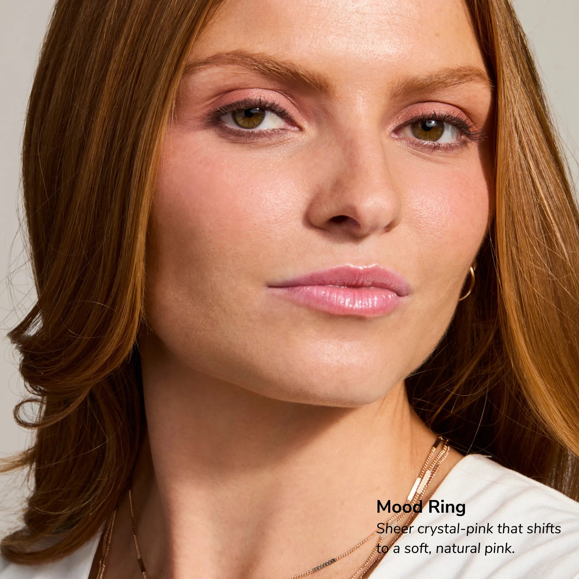 Close-up of a woman with pink blush and soft pink lips showcasing Mood Ring lip tint