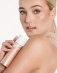 Model holding Illuminating Moisture Mist product shade Champagne.