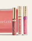 Three LipSense products with gold floral caps beside a pink zipper pouch