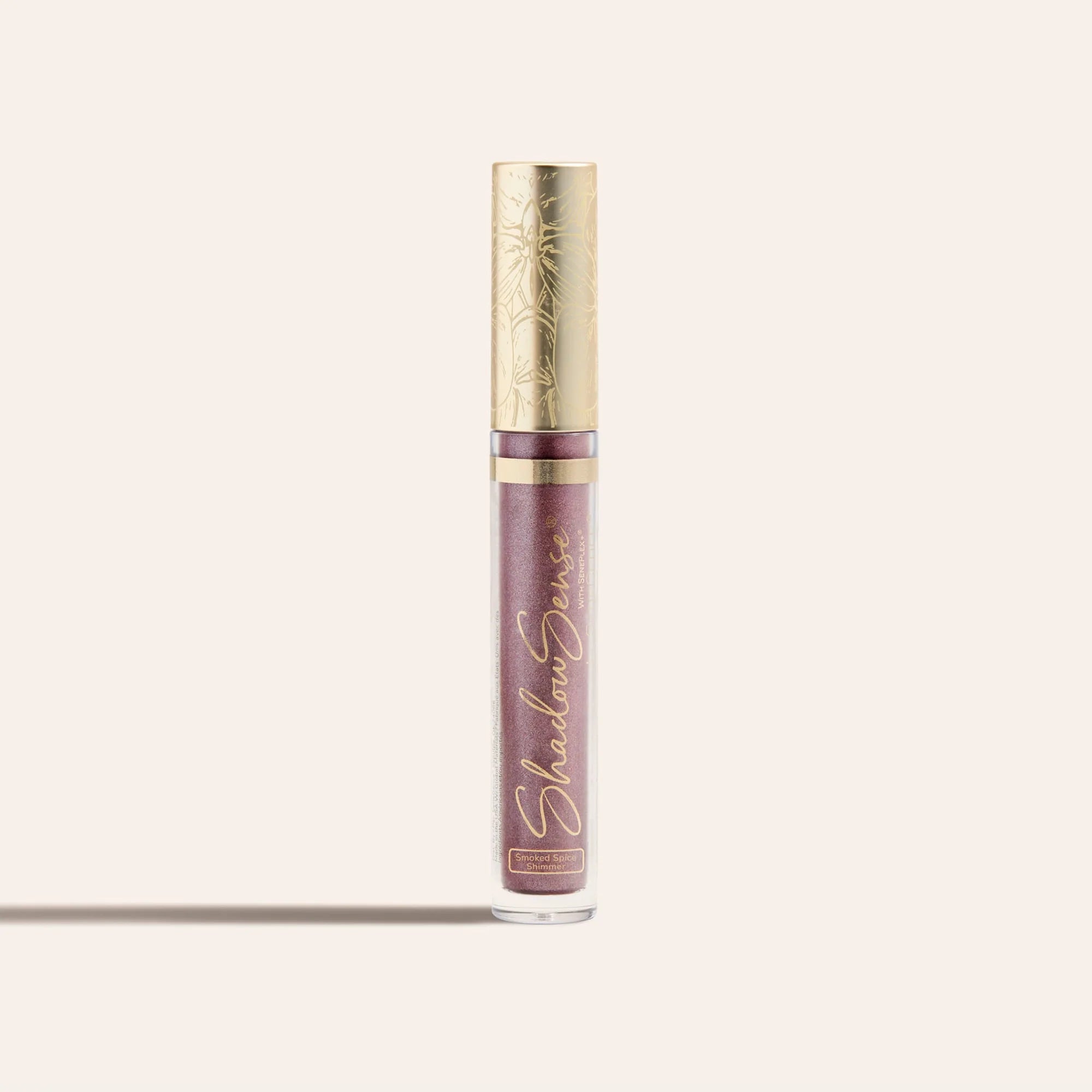ShadowSense Eyeshadow NZL in a tall clear tube with purple glittery formula and an ornate gold cap