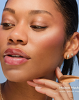 Model wearing Pearlizer Highlighter product shade Molten Mocha